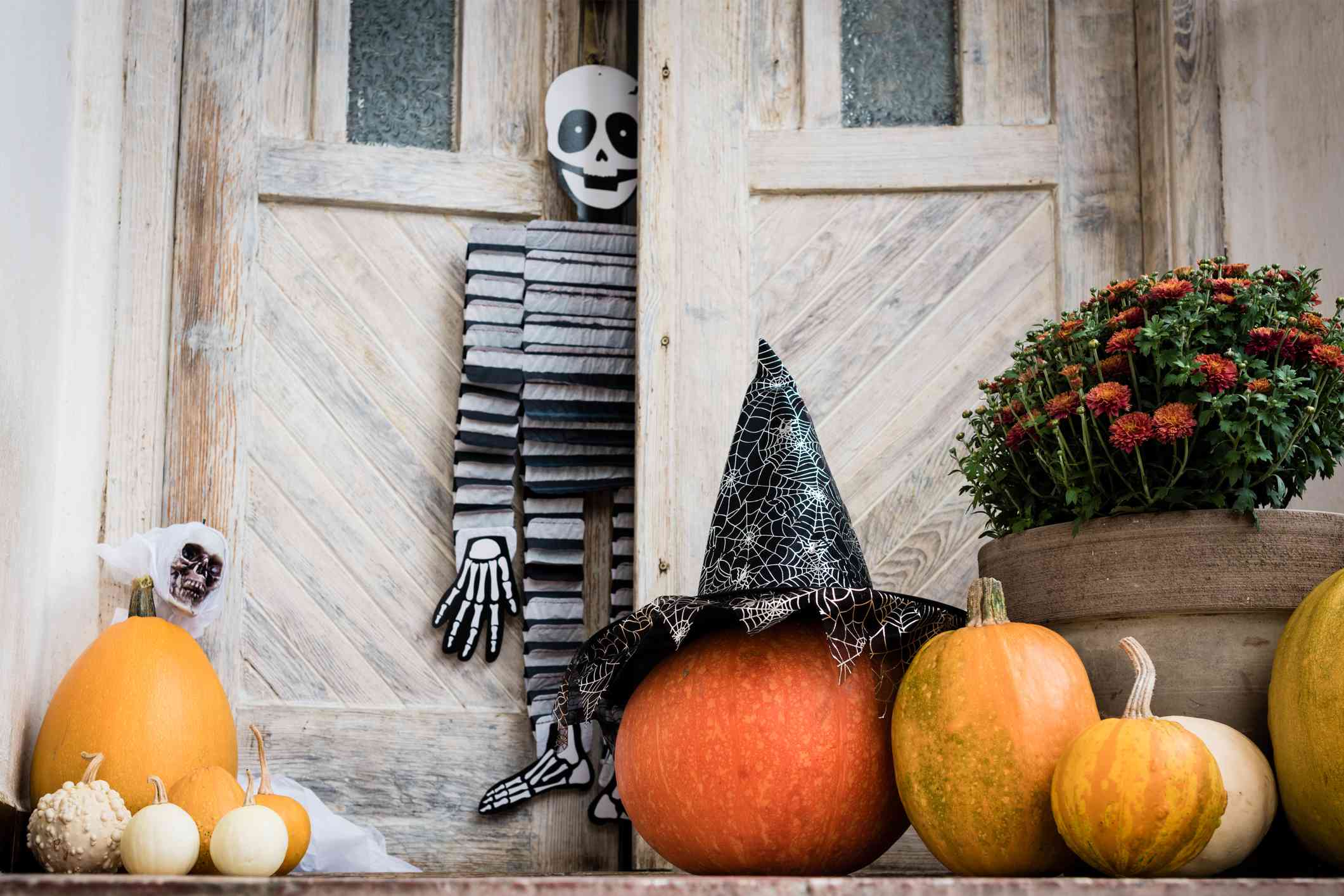 Front Page -Spook & Style Shop halloween decorated front door with various size and shape pumpkins and skeletons front porch decorated for the halloween season 1042539328 88cd53b25bd54457afc89f755cdf995f